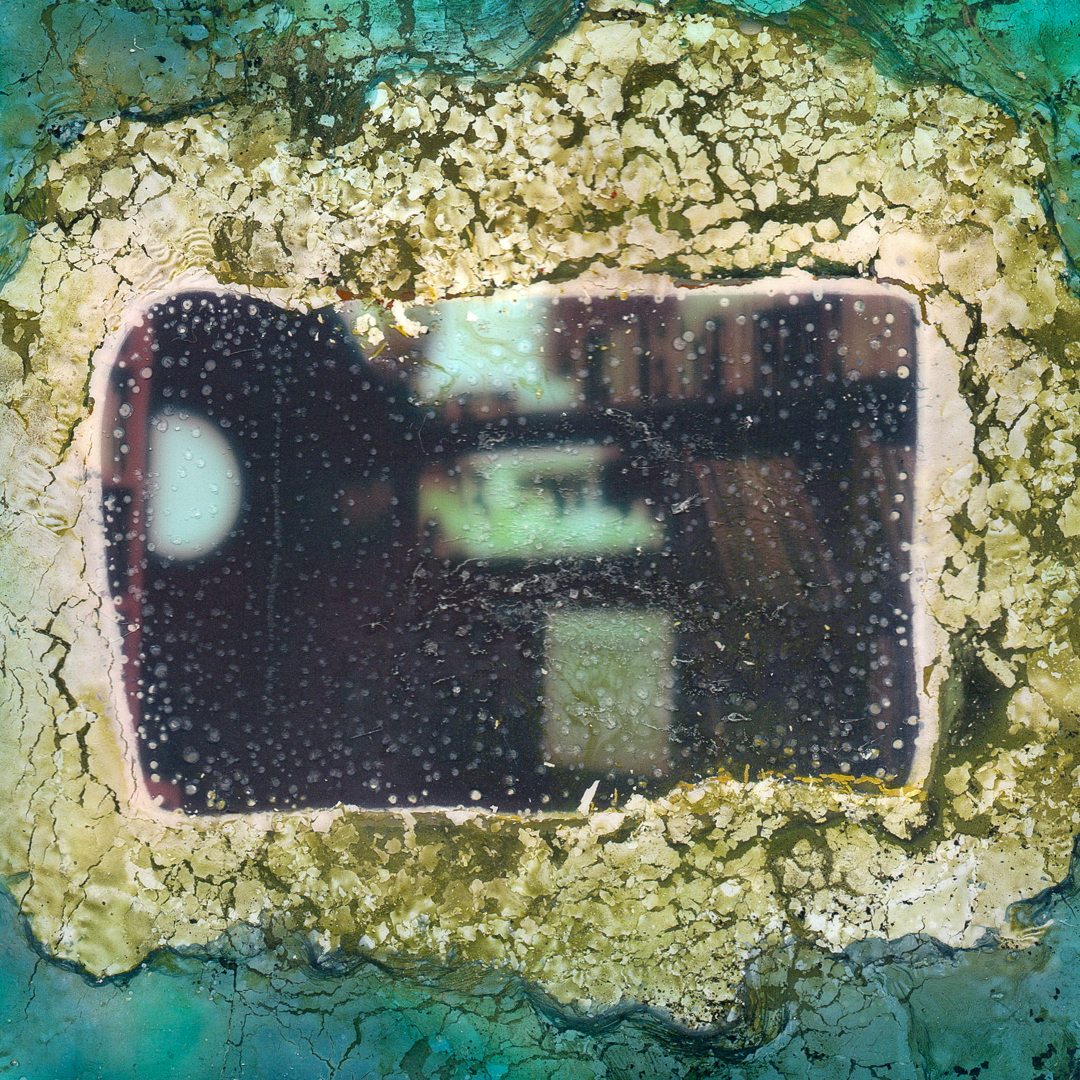 A Polaroid image that has been decayed through a chemical soak.
